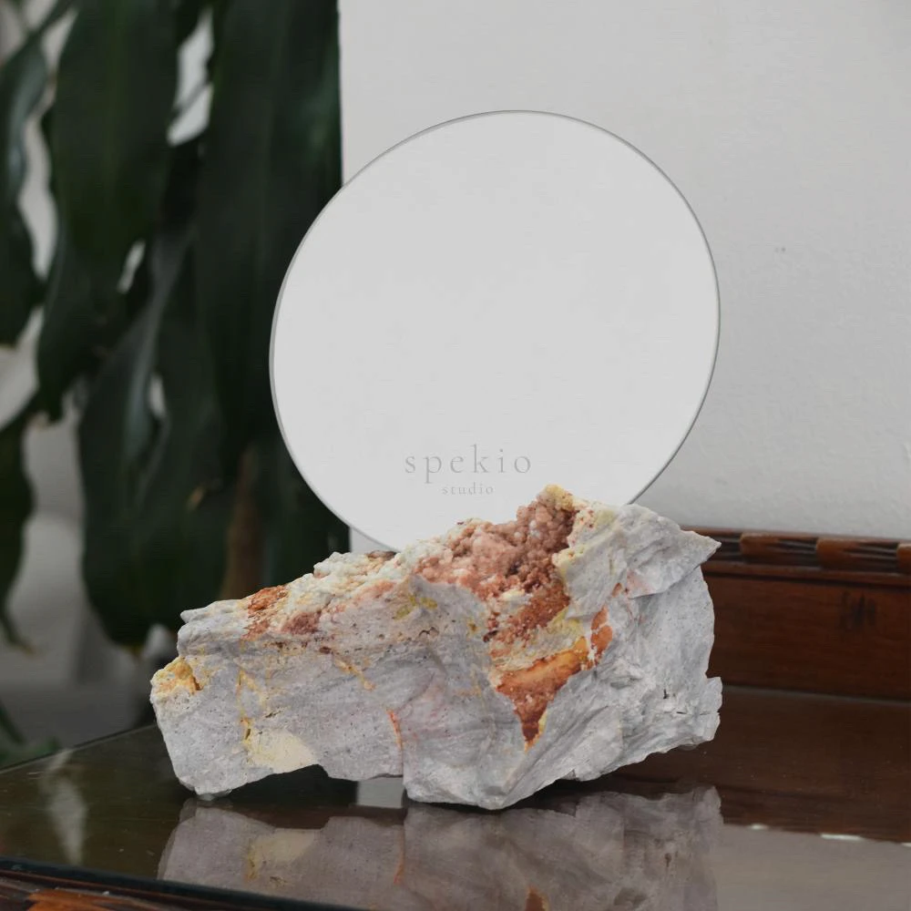 Spekio Studio — espejo redondo sobre base de piedra